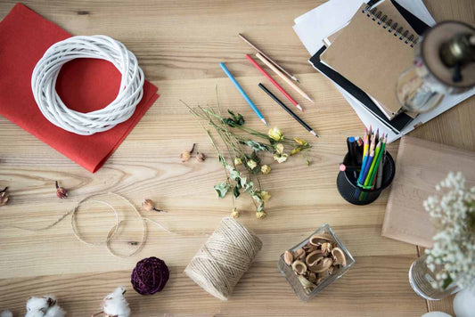Natural-coloured waxed cord with craft supplies on a wooden table for DIY projects